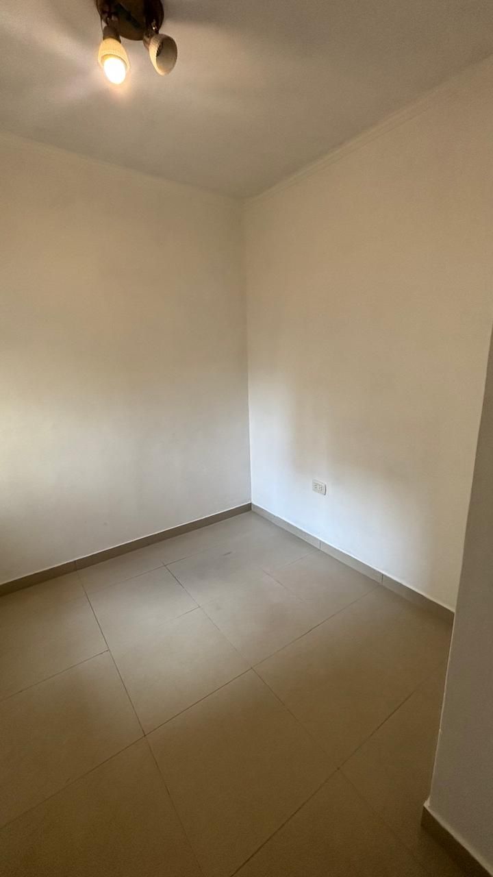 Dormitorio vacío con piso cerámico y plafón en el techo