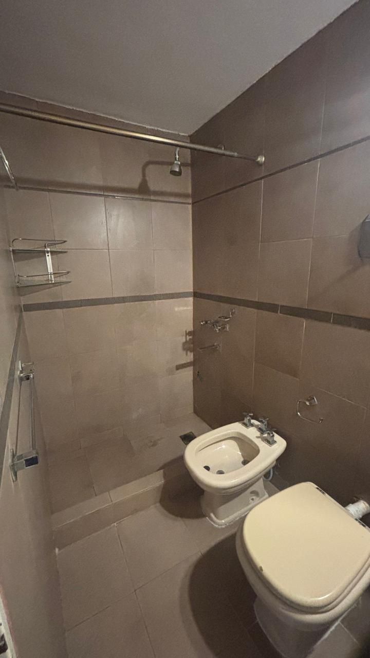 Baño con ducha, bidet e inodoro, revestimiento marrón
