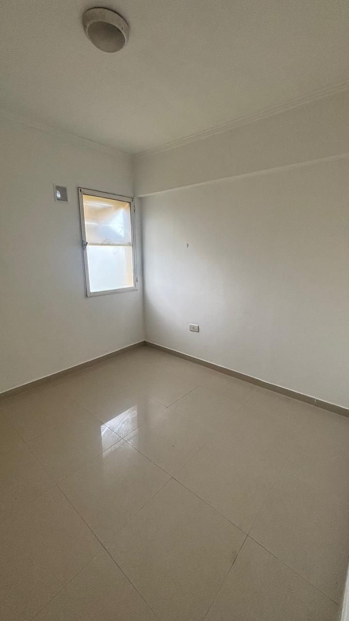 Dormitorio con ventana pequeña y piso cerámico