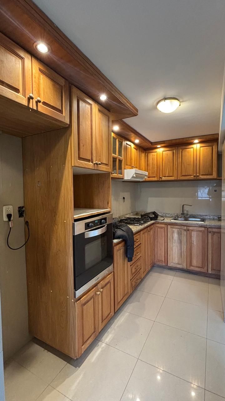 Vista general de la cocina con alacenas de madera y luces embutidas